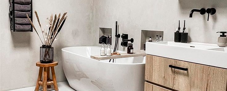 Vrijstaand bad met zwarte badkamer accessoires en hout badkamermeubel